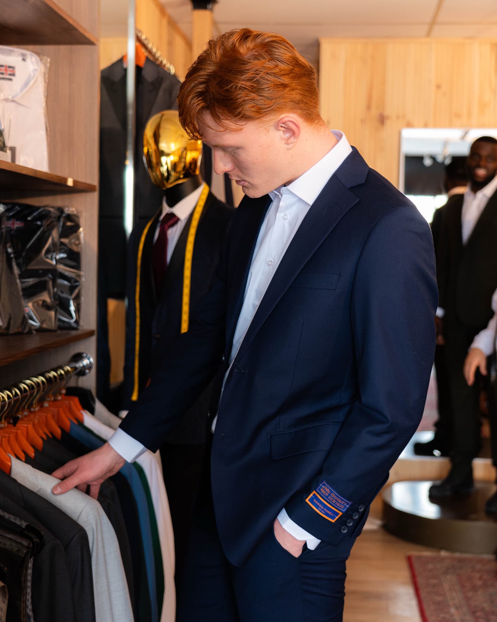 Model browsing the curated suit collection in store